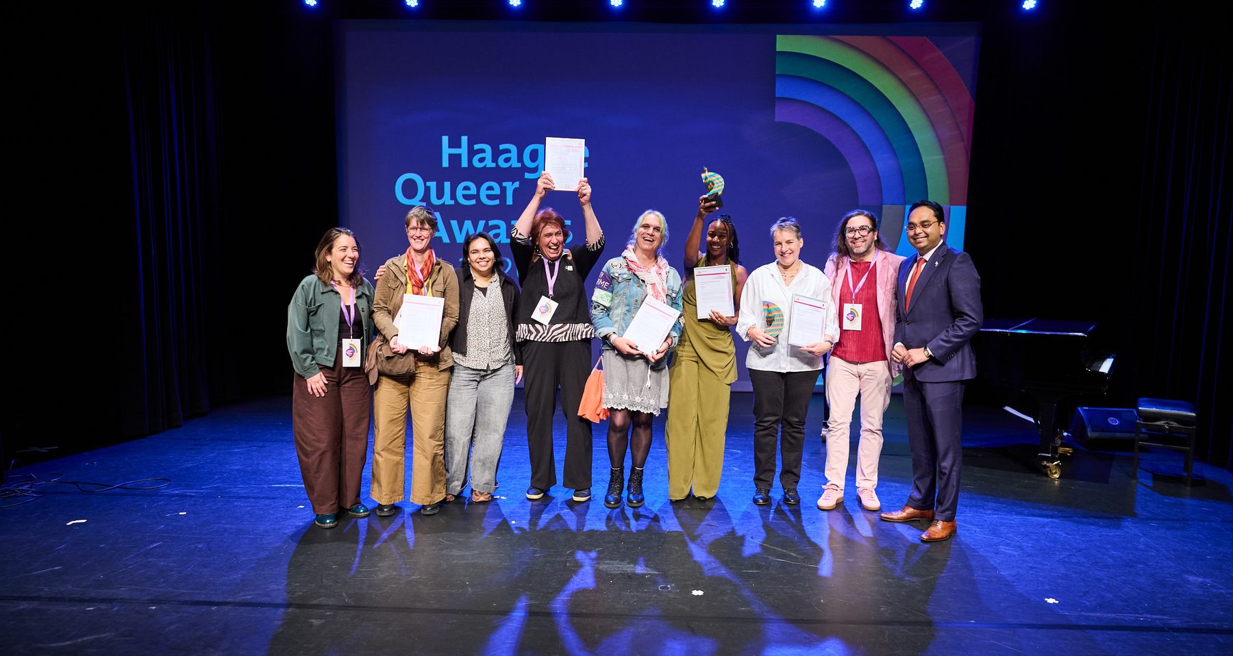 Winnaars en genomineerden van de Haagse Queer Awards 2026 met wethouder Kavish Partiman op het podium van het Koorenhuis